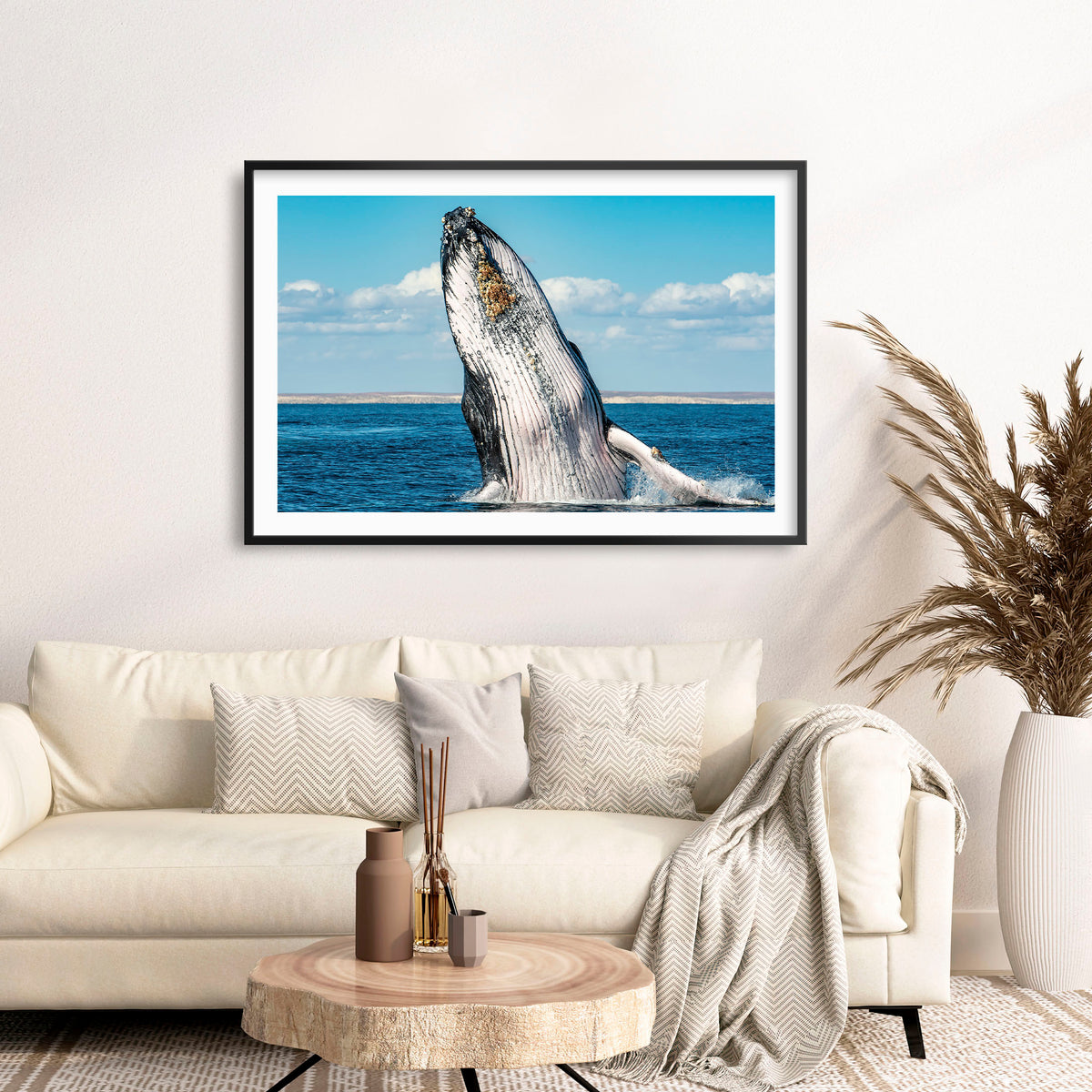 Room mockup above a sofa: Humpback Highway — humpback whale breaching above the sea.
