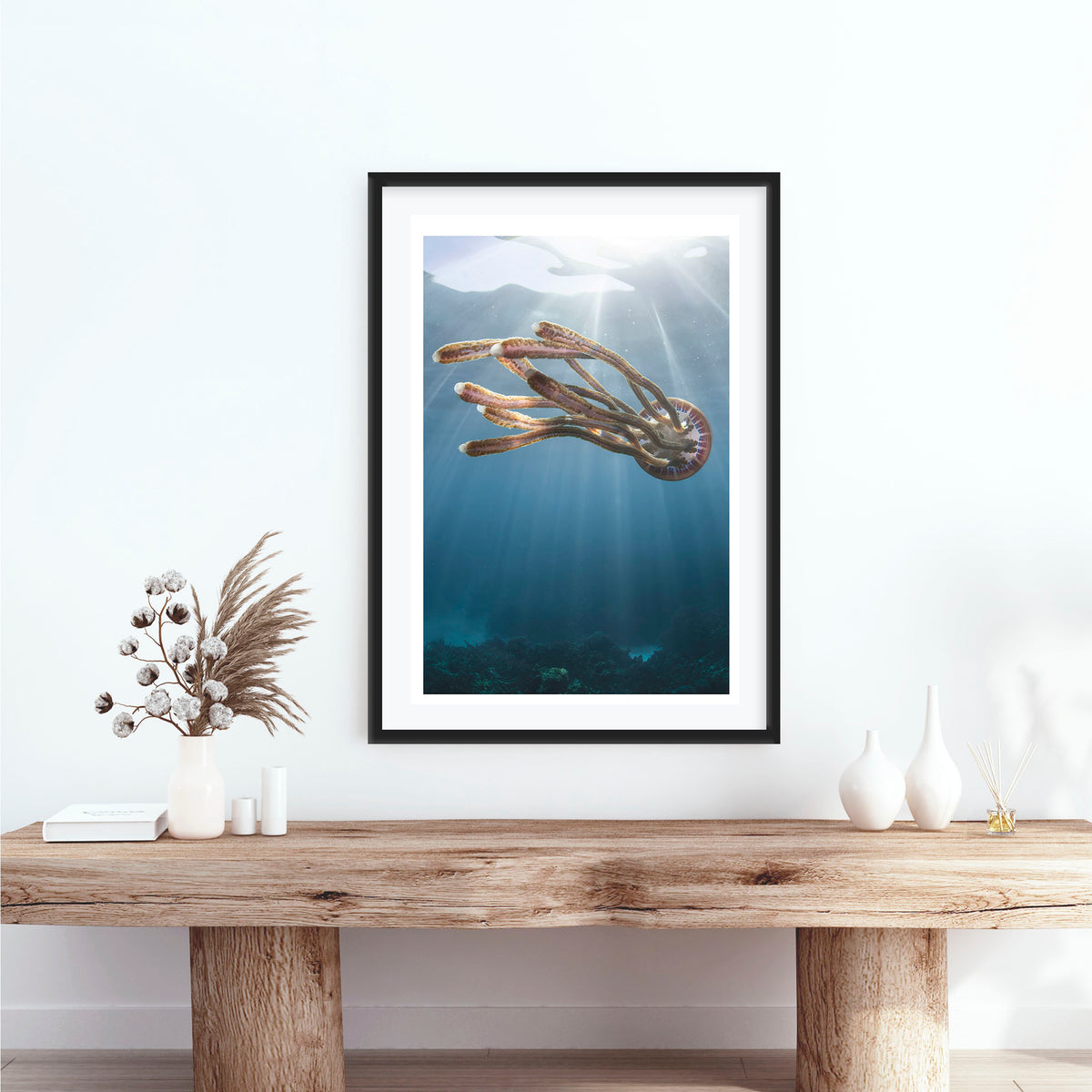 Room mockup above a console table: Rasta jelly — jellyfish beneath shafts of sunlight.